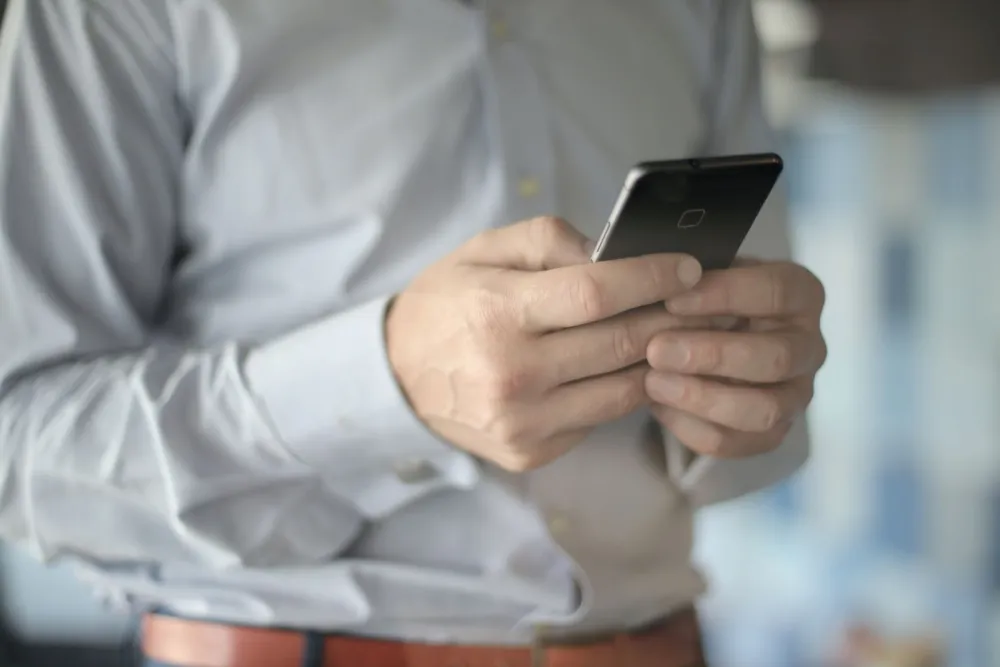 Private security employee holding a smartphone